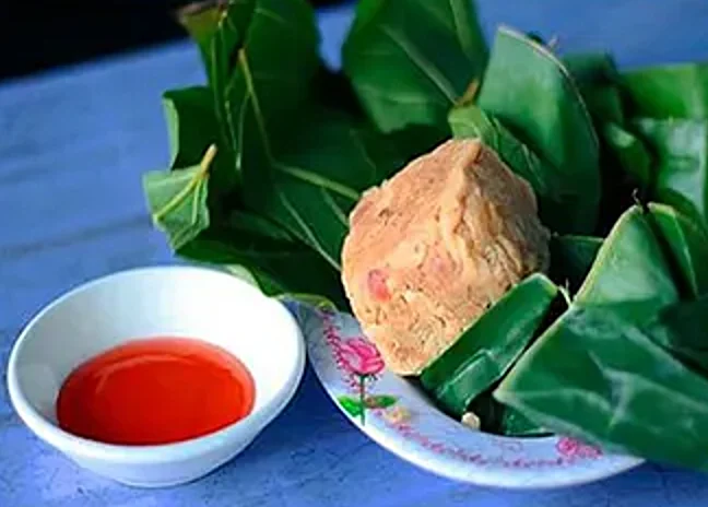 Một miếng nem bùi Hải Tuyết đặt trên lá chuối, cạnh bát nước chấm